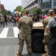 As a Drug Enforcement Agency police office and National Guard soldiers watch, demonstrators protest Saturday, June 6, 2020, in Washington, over the death of George Floyd.